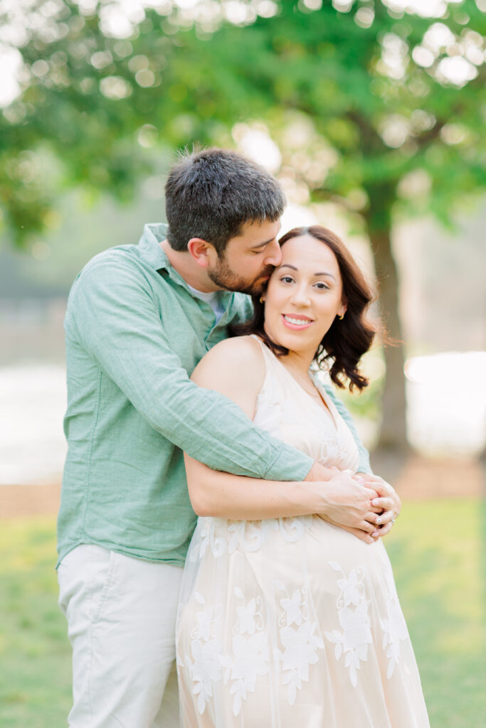husband kisses wife's forehead during photo session in Rob Fleming Park