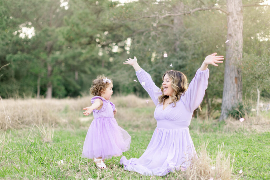 Mommy and daughter tossing flower petals at East End, Park, Texas
