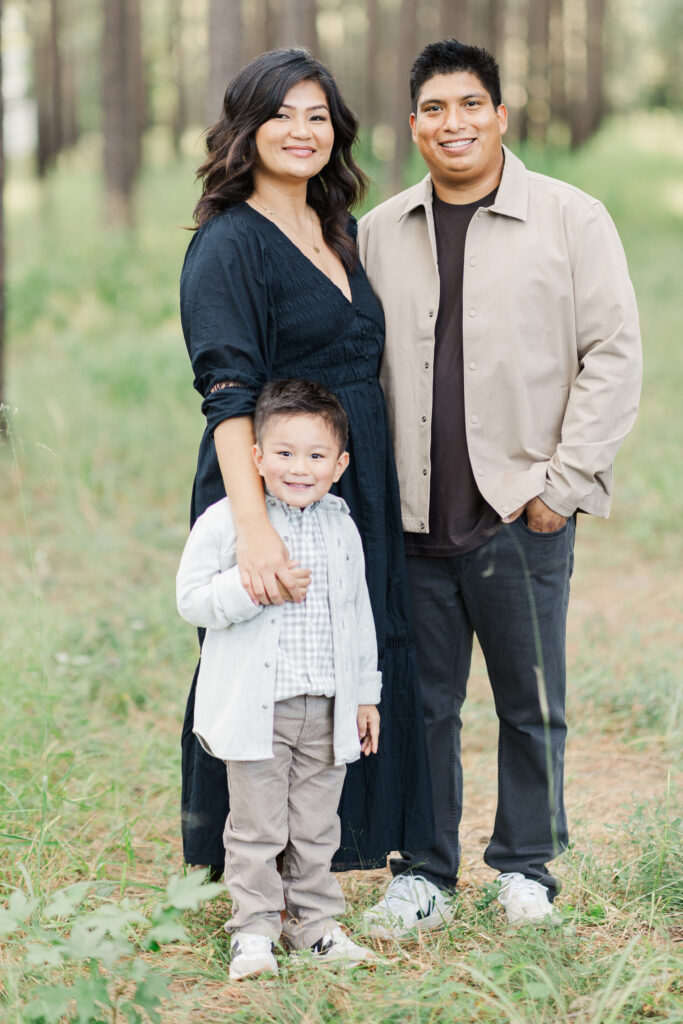Family smiles at camera in whimsial woods photo location in Houston