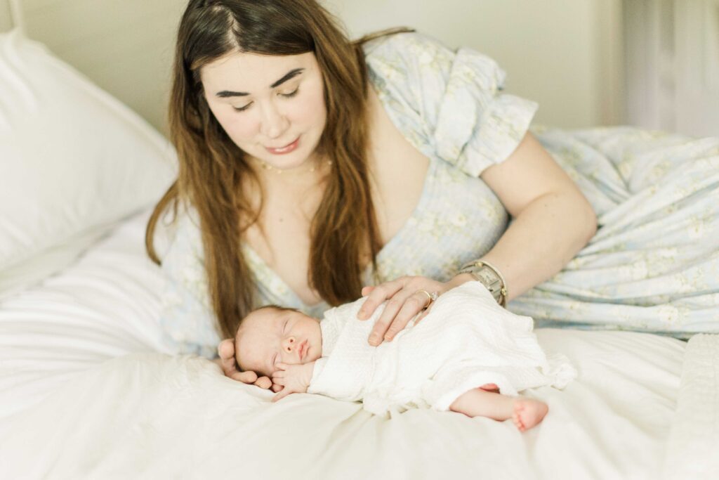Mom lays on her side snuggled baby close to her